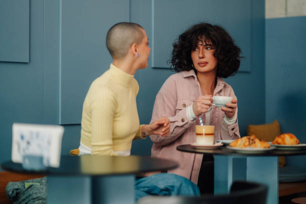 istock Two young women talking and drinking coffee in a cafe 2215311181