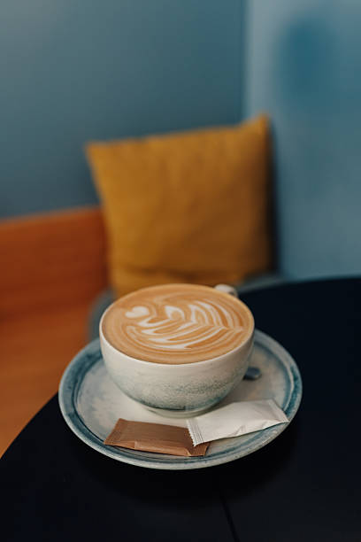 Latte art coffee cup resting on a table in a cafe