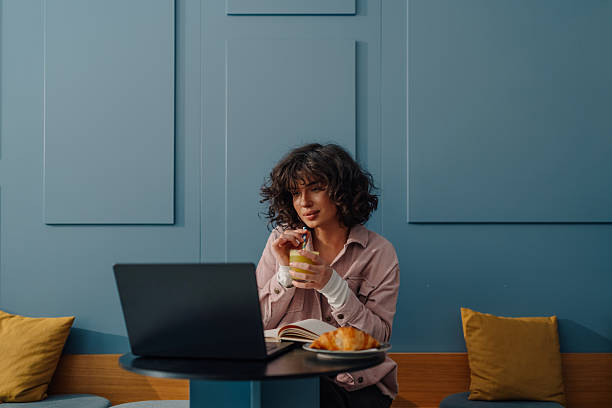 istock Freelancer working remotely in cafe, enjoying breakfast and doing business 2215311236