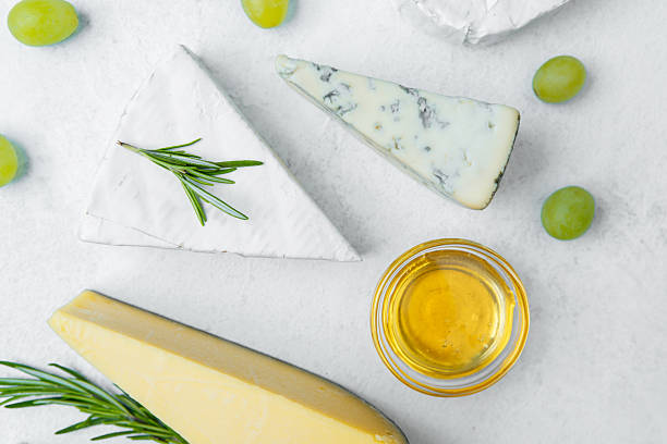 istock Cheese platter with grapes and honey on a light surface 2215312620