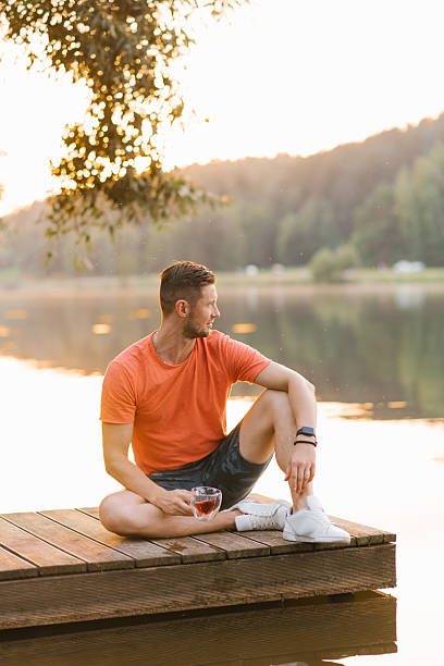 istock Father Man Relaxing On Dock With Tea At Sunset 2215319512