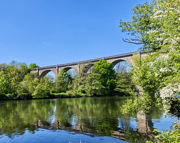 istock Old railway viaduct reflecting in the river on sunny spring day 2215321985