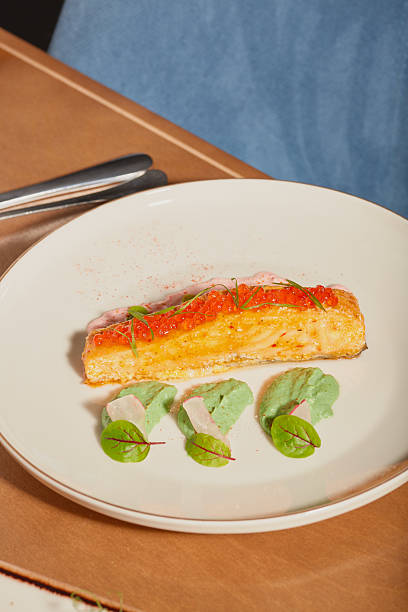 Colorful salmon dish served on a white plate with green accents in a culinary setting