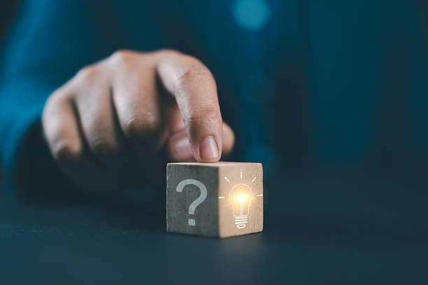 Hand touching Glowing light bulb on bright side and question mark on dark side of wooden block cube for problem solving solution and creative thinking idea innovation concept. Hand touching Glowing light bulb on bright side and question mark on dark side of wooden block cube for problem solving solution and creative thinking idea innovation concept. FAQ stock pictures, royalty-free photos & images
