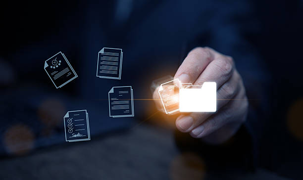 istock Document Management System concept. A man drags and drops files into DMS software to store, share, track and manage files or documents. 2215332912