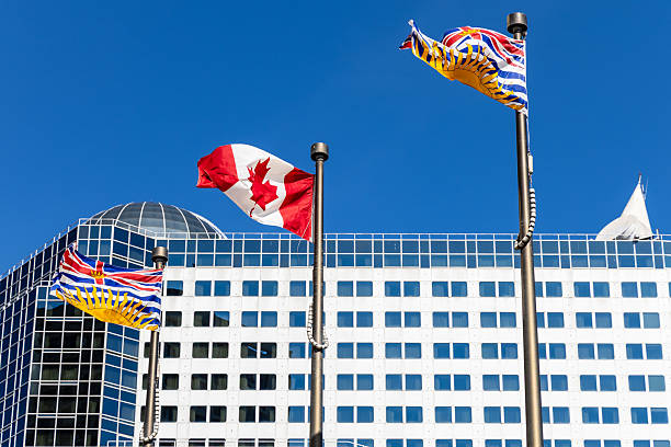 Canadian and British Columbia flags blowing in the wind in downtown Vancouver.