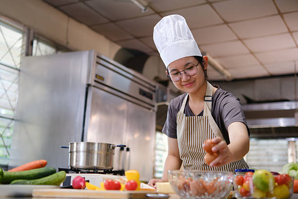 istock Chef picking fresh brown eggs from a glass bowl in a kitchen filled with colorful produce 2215333208