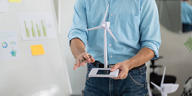 istock Sustainability in Action. Professional presenting wind turbine model for eco-friendly solutions. 2215336460