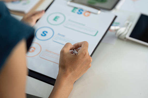 istock ESG Focus. Individual analyzing Environmental, Social, and Governance metrics on a clipboard. 2215336469