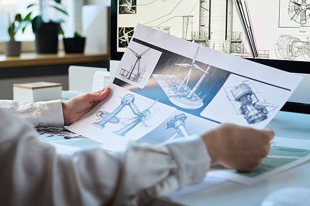 istock Unrecognizable Engineer Holding Printed Paper with Wind Turbine Drawings 2215339638
