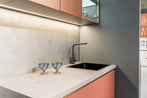 istock built-in peach-colored kitchen with beautiful facades. Kitchen with upper and lower cabinets, countertop, sink and faucet. Upper cabinets with glass doors. beautiful glasses in cupboards. kitchen unit 2215349121