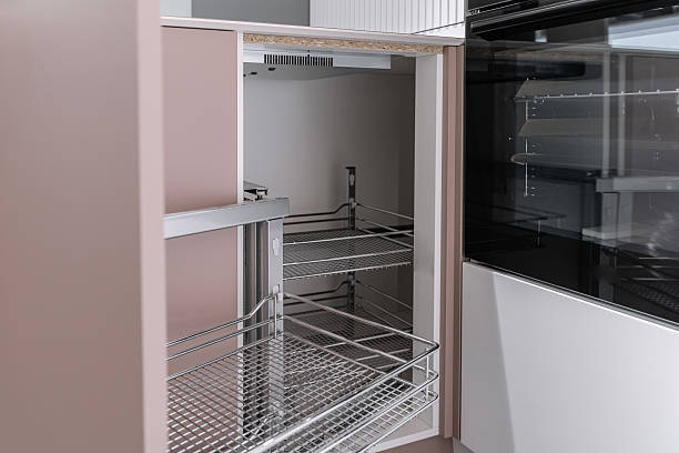 istock stylish modern built-in kitchen with upper and lower cabinets, drawers, shelves. kitchen facades are white and peach in color. Large, bright kitchen unit. Built-in kitchen appliances. white countertop 2215349155