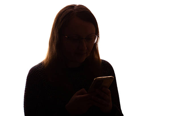 istock Silhouette of young woman using smartphone on white background 2215349596