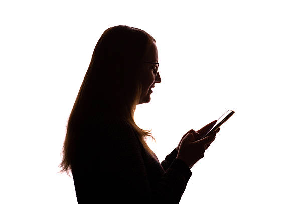 istock Silhouette of young woman using smartphone on white background 2215349600
