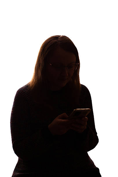 istock Silhouette of young woman using smartphone on white background 2215349609