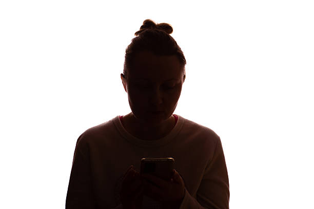 istock Silhouette young woman with hair up using smartphone, white background 2215349677