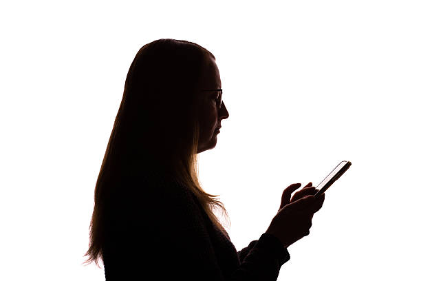 istock Silhouette of young woman using smartphone on white background 2215349686