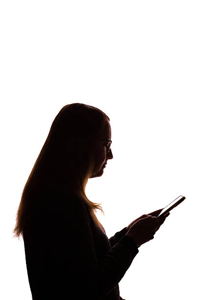 istock Silhouette of young woman using smartphone on white background 2215349729