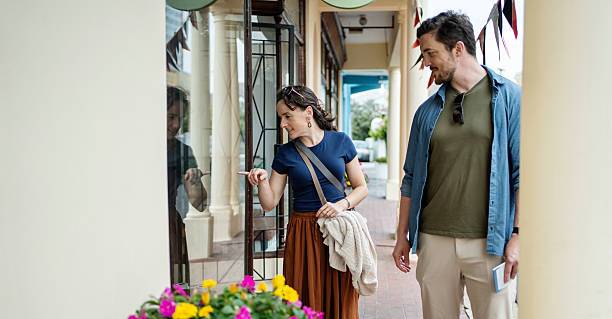 istock Woman pointing at shop window with man looking on 2215350138
