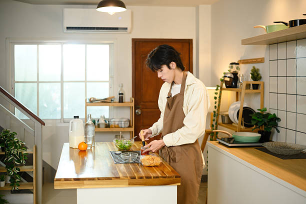 istock Young asian man preparing healthy vegetable salad in modern kitchen 2215351901