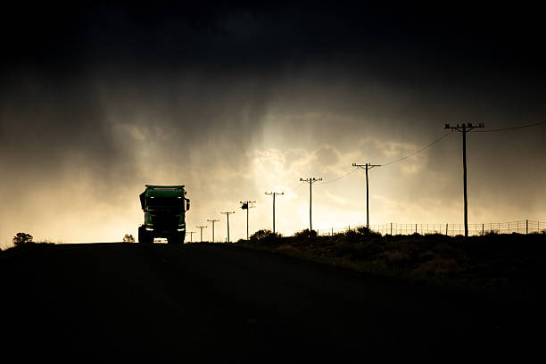 Trucking on the road against Dramatic stormy clouds