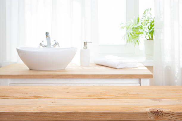 istock Empty wooden table top as mock up for product montage on blurred bathroom sink interior  background 2215356901
