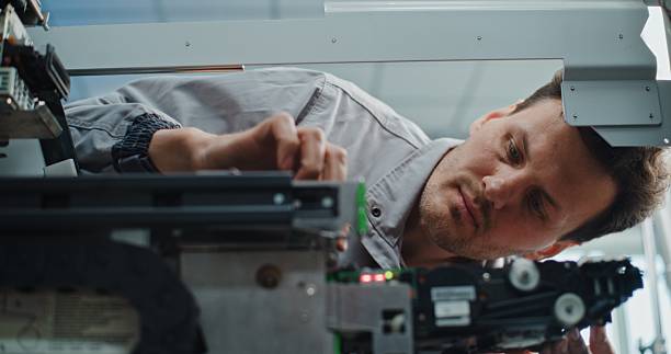 istock ATM Technician in Uniform Performing Maintenance of Cash Dispenser Machine 2215358826