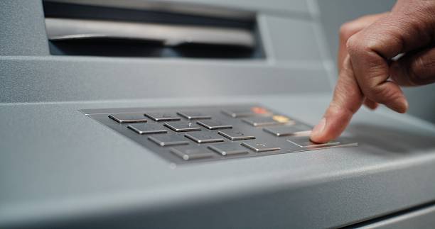 istock ATM Machine: Close Up of Unrecognizable Man Entering PIN Code for Cash Withdrawal Transaction 2215358969