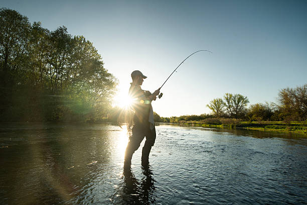 istock Fisherman enjoying fly fishing in river during evening light. 2215359414