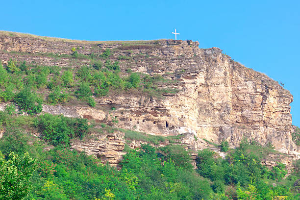 istock Rugged mountainside with religious cross atop the peak 2215360473