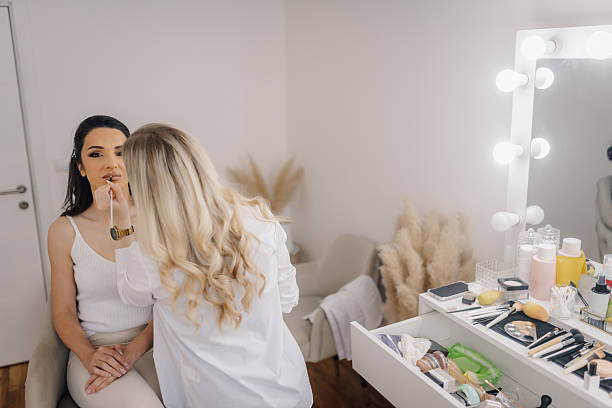 istock Makeup artist applying lipstick on client's lips in beauty salon 2215363234