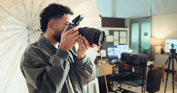 istock Photographer, camera and man in studio, skills and backstage with tech, entrepreneur and project. Person, employee or guy with professional, business for pictures and media agency for magazine 2215367788