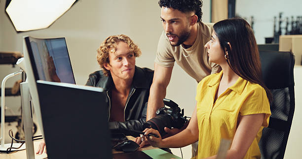 istock People, computer and teamwork for photography in studio for production results, talking and review. Staff, producer and group to check for fashion photographer, magazine catalog and filming process 2215367889