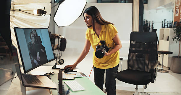 istock Editing, photographer and woman with camera, computer and creative for project in studio or serious. Business, artist and person with tech for photography, post production and choice of picture 2215367893