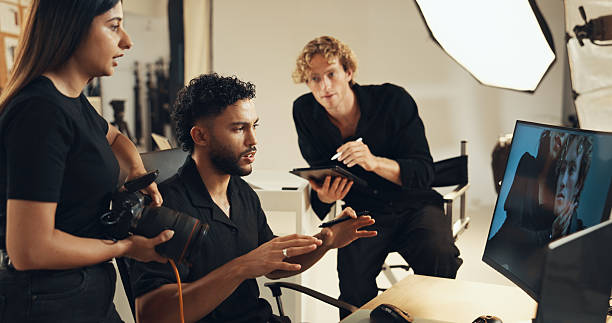 istock People, backstage or talking for photography or teamwork for production results, planning or review. Studio, producer or computer to check for fashion photographer, magazine catalog or filming ideas 2215367946