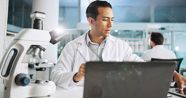 istock Microscope, science and laptop with man in laboratory for dna sample, forensics investigation and healthcare. Research report, genetic analysis and medical test with person for pathology and clinic 2215368591