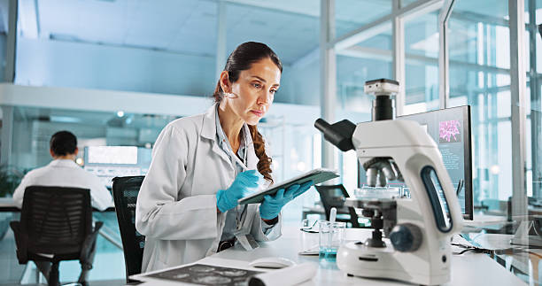 istock Laboratory, woman and tablet with study for biology, breakthrough or medical notes analysis. Biotech, scientist and microscope with DNA research for pharmaceutical RNA or neurology experiment project 2215368677