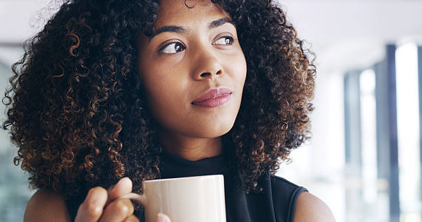 Woman, office and thinking with coffee for morning beverage, start or beginning at workplace. Face, female person or thoughtful designer with caffeine or drink in wonder for ambition or inspiration