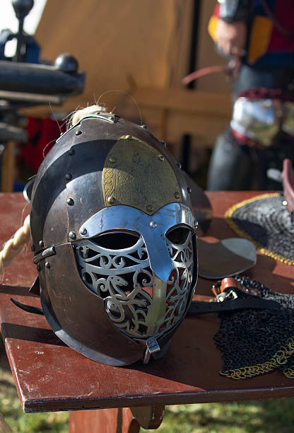 istock Medieval knight armor with helmet, sword, axe, and chainmail on display at historical reenactment event or fair. 2215370529