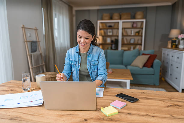 istock Young freelance business woman having video call conference on laptop computer while sitting and working at home, talking on webcam with potential investor in her project. Finance and economy concept. 2215374803