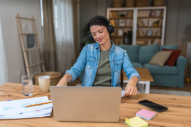 istock Young freelance business woman having video call conference on laptop computer while sitting and working at home, talking on webcam with potential investor in her project. Finance and economy concept. 2215374822
