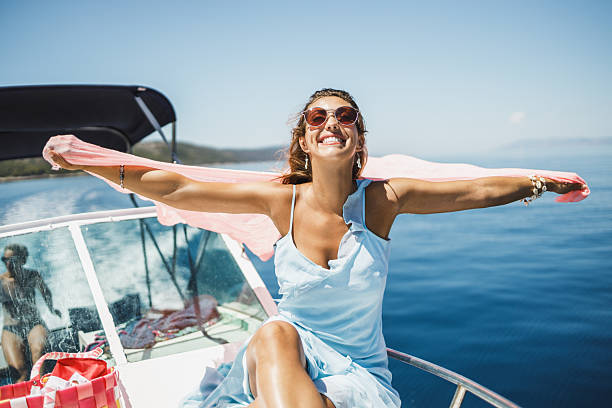 Shot of an attractive young woman with scarf having fun while enjoying a day on her private the yacht.