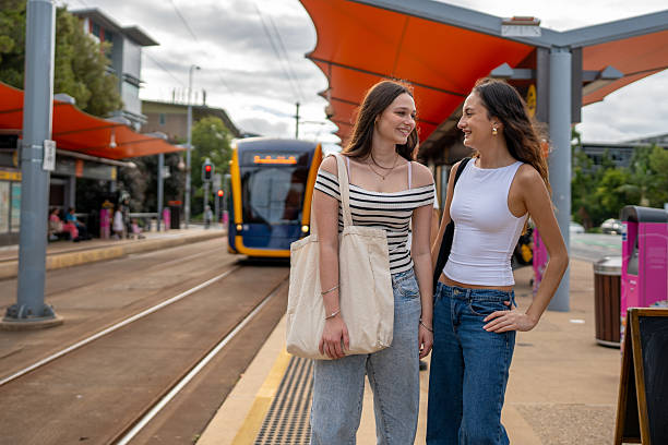 istock Two Friends Smiling at Tram Stop 2215379942
