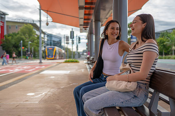 istock Two Young Women Sitting at Tram Stop 2215379980