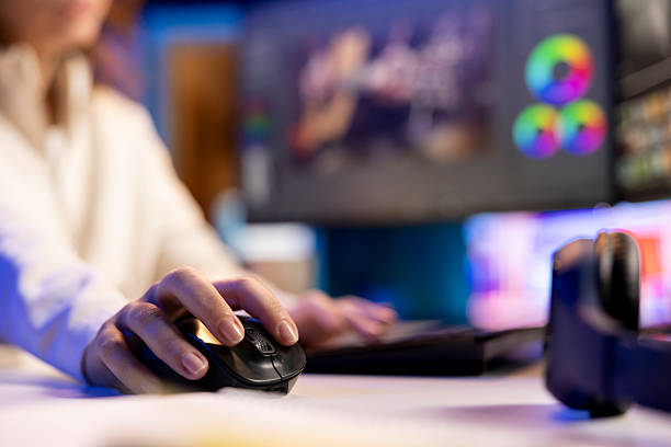 Focus on mouse used by post production videographer Professional video editor editing color grading and lighting in creative office, analyzing film montage, close up shot. Focus on mouse used by post production videographer manipulating raw footage female film editor stock pictures, royalty-free photos & images