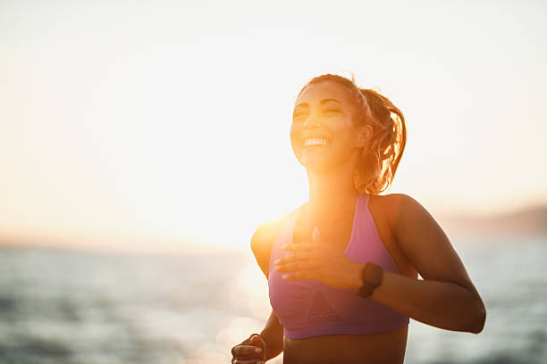 Young woman is running along the sea shore on the beach and enjoying in summer sunny day.
