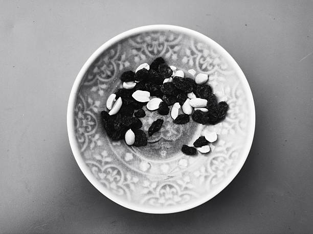 A bowl with an oriental pattern filled with raisins and nuts