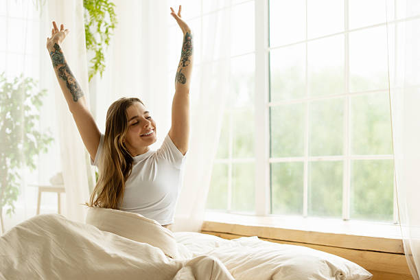 istock Young Woman Stretching in Bed After Waking Up 2215387259