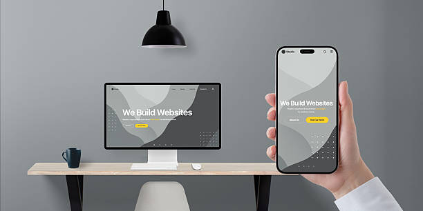istock Digital transformation concept with responsive business website shown on phone and desktop display, hand holding device in modern office 2215388163