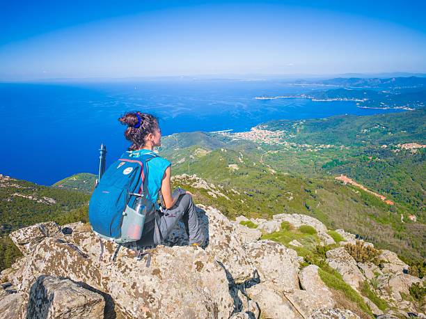 Isola d'Elba, Italy - 1 May 2025 - The touristic island of Tuscany region, with awesome landscape sea, beach and trekking path named GTE, with alpinistic and ferris ways. Here in particular a view from Monte Giove summit with hiker
